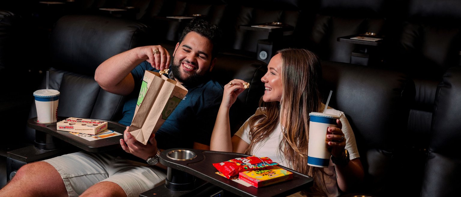 Couple eating popcorn in movie theater