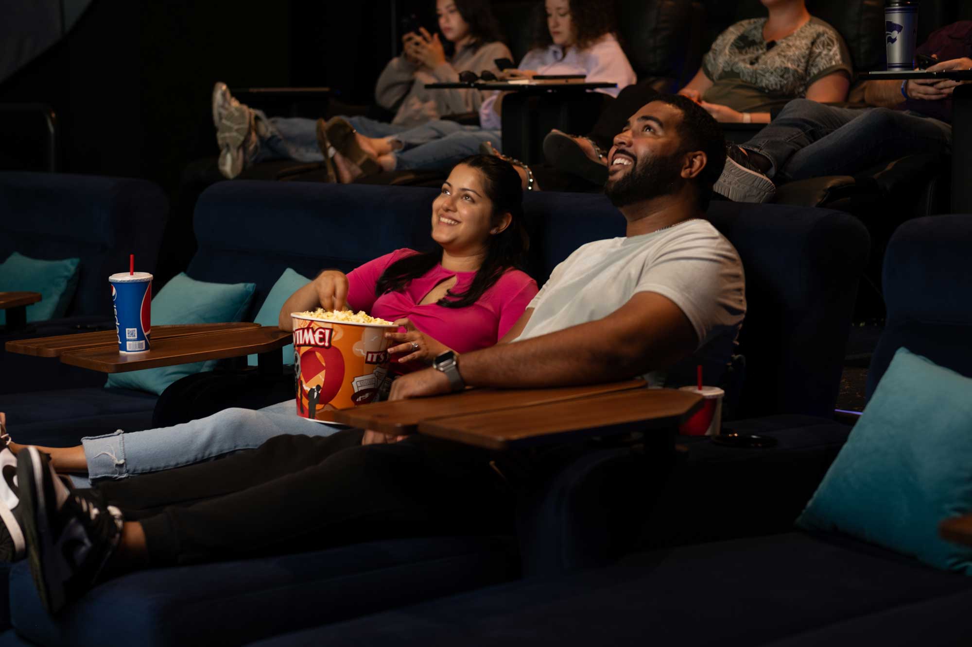 Couple watching movie from a cinema bed