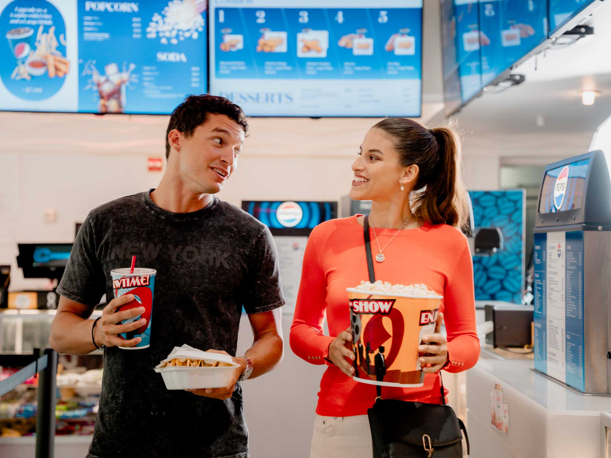 Couple holding movie concessions