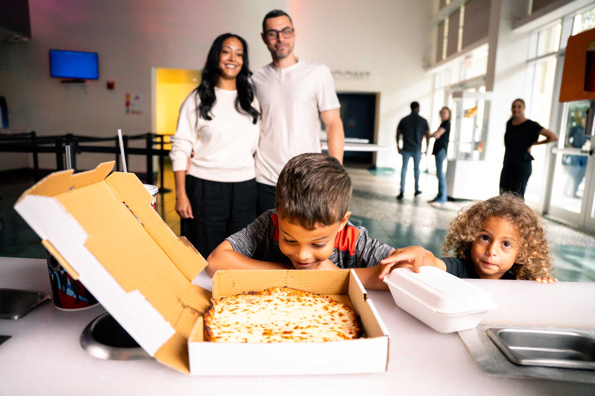 Family with pizza in movie theater lobby