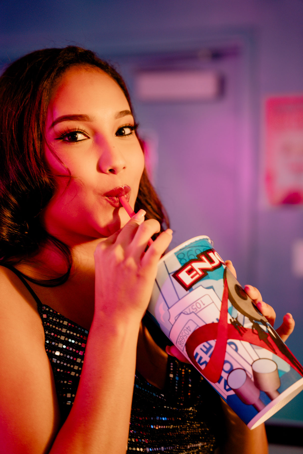 Woman drinking from a cup with a straw