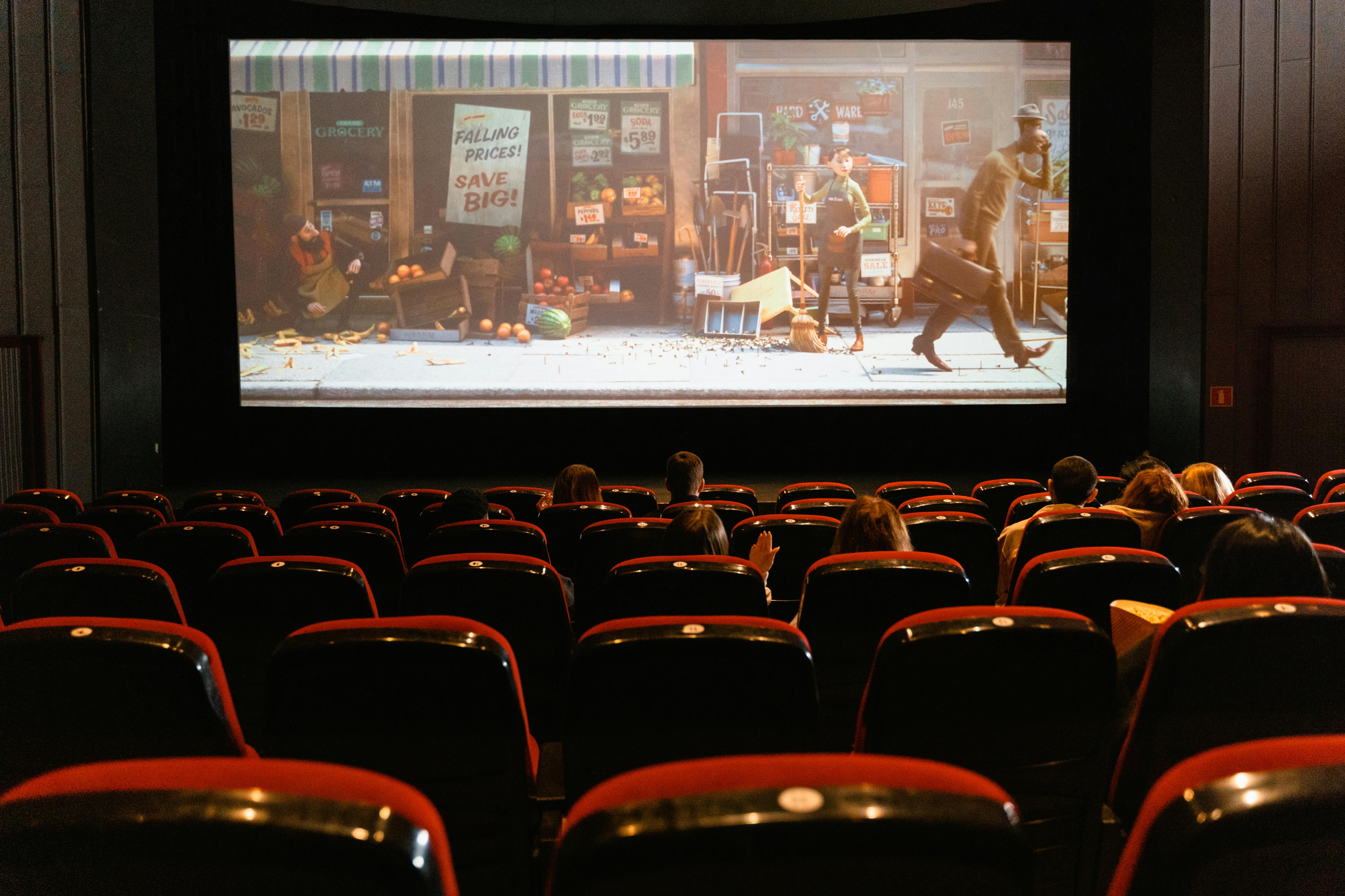 Movie theater full of people looking at the screen that says your ad here
