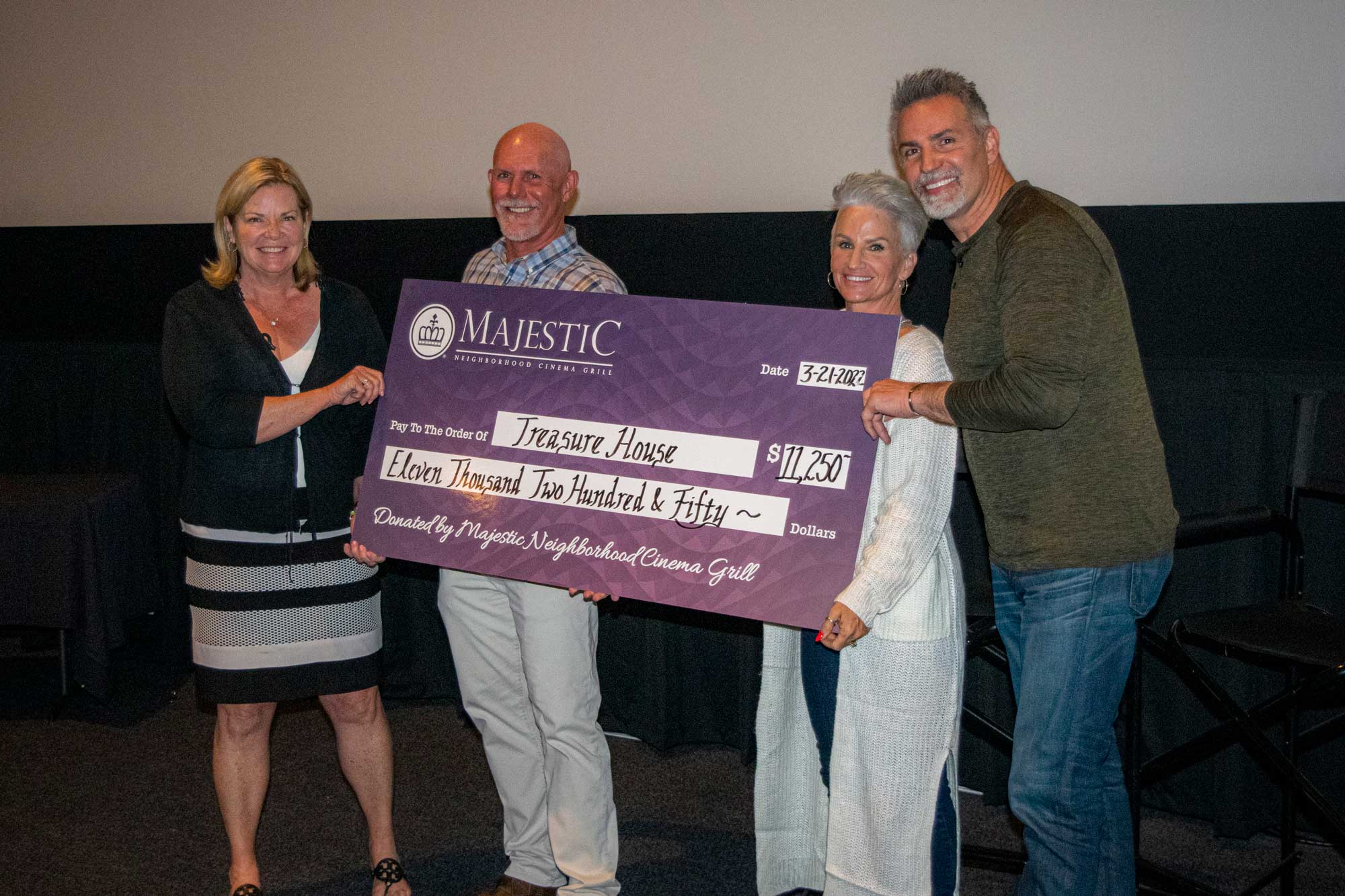 People holding a large check from Majestic, to Treasure House