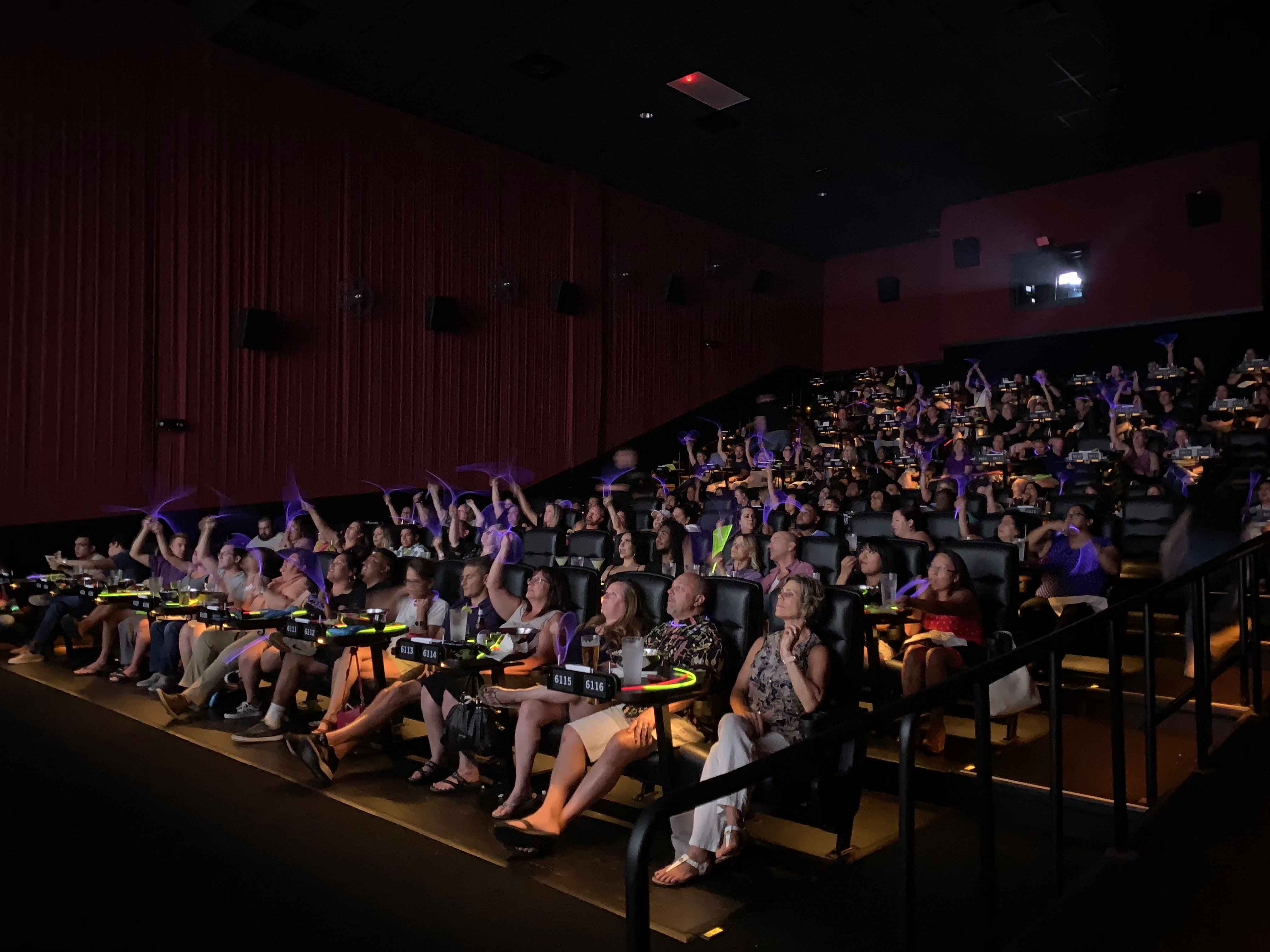 People at a movie theater event with glow sticks