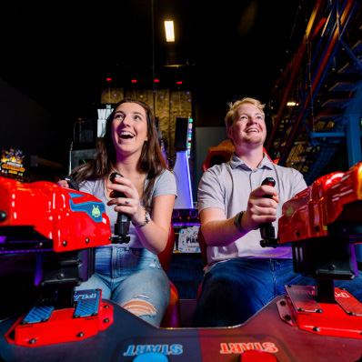 People smiling holding arcade game controllers