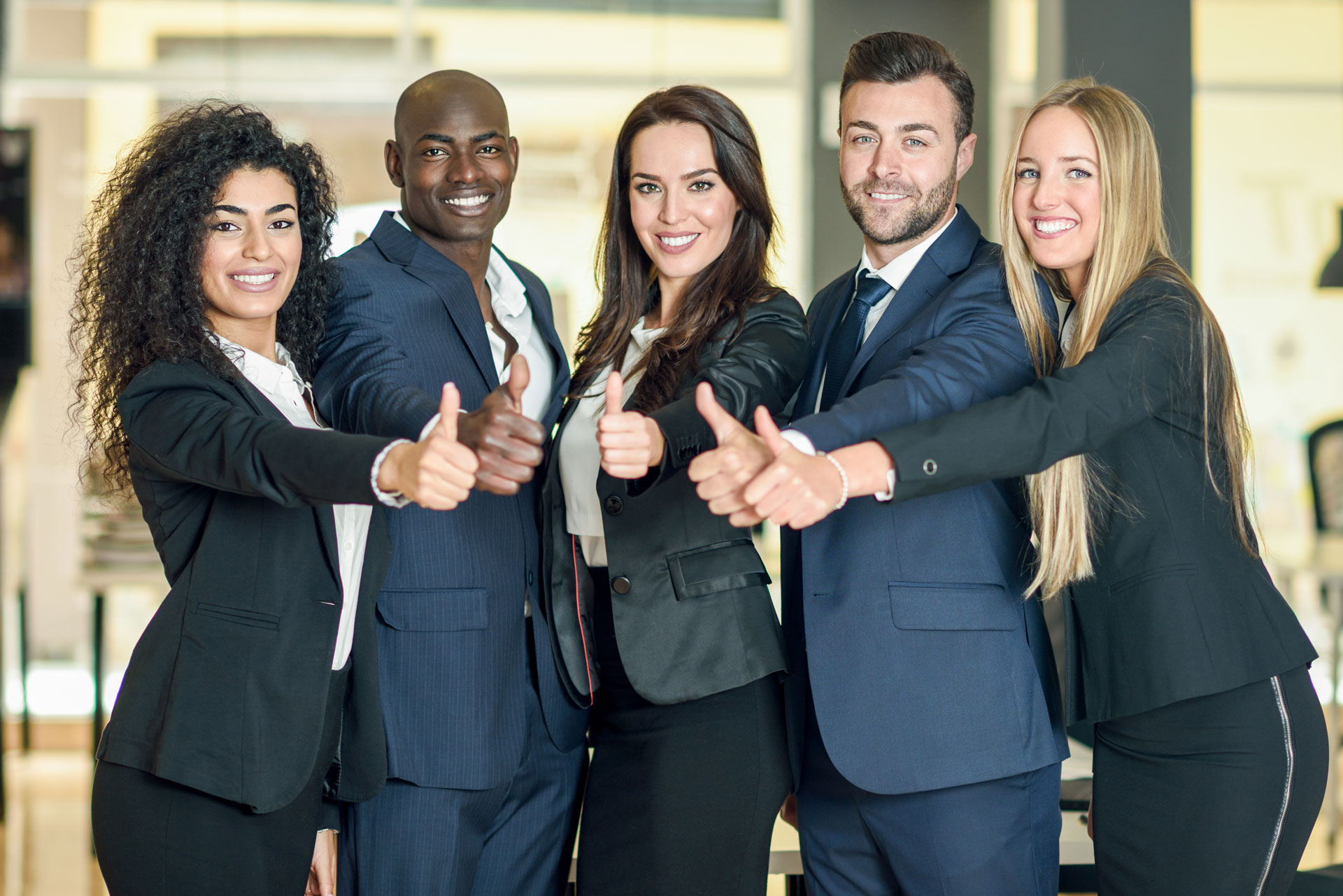 People wearing suits smiling and giving a thumbs up