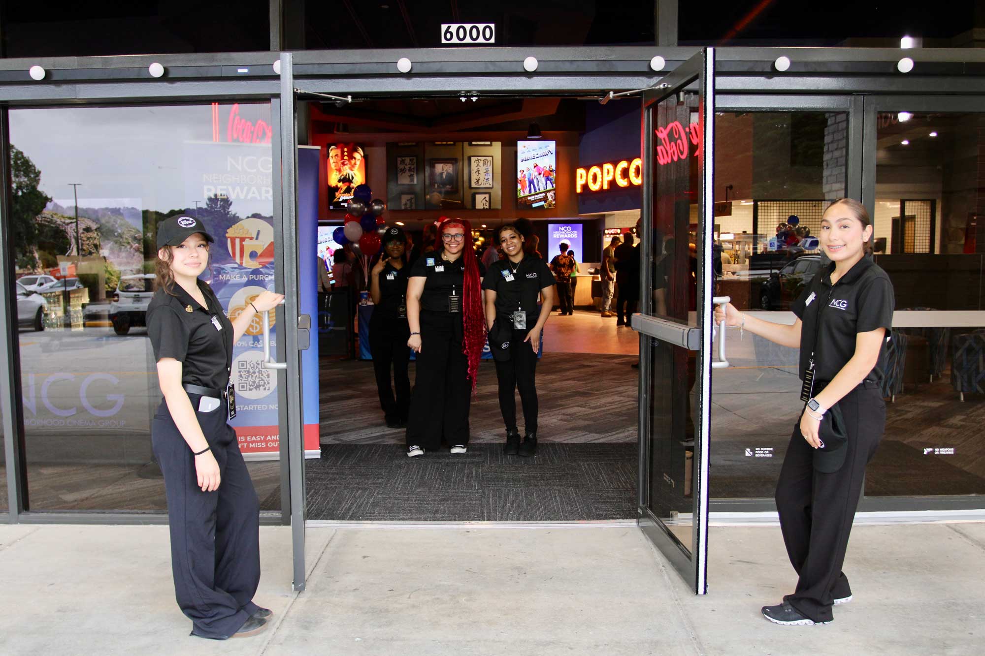NCG employees holding the front doors open