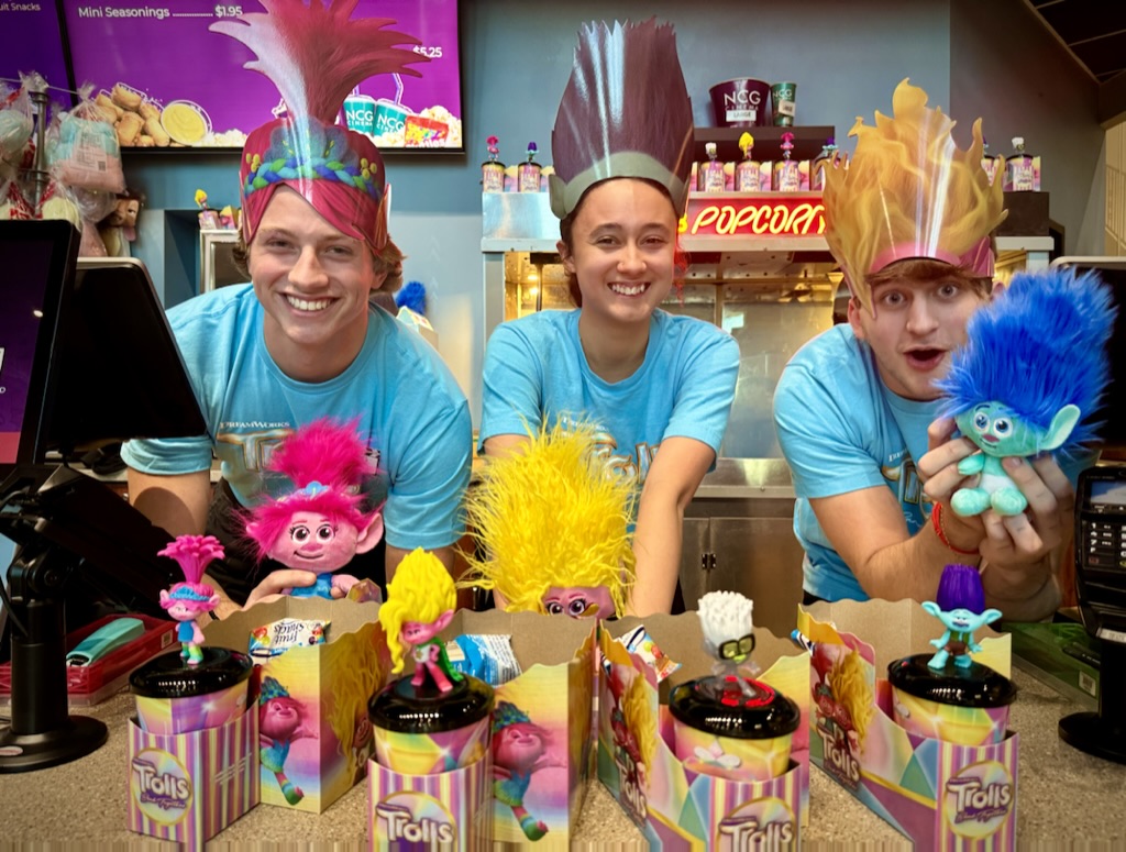 People displaying Trolls merchandise at a concessions counter