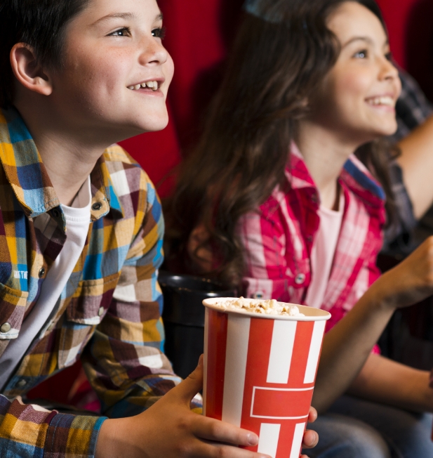 Smiling kids with movie theater popcorn