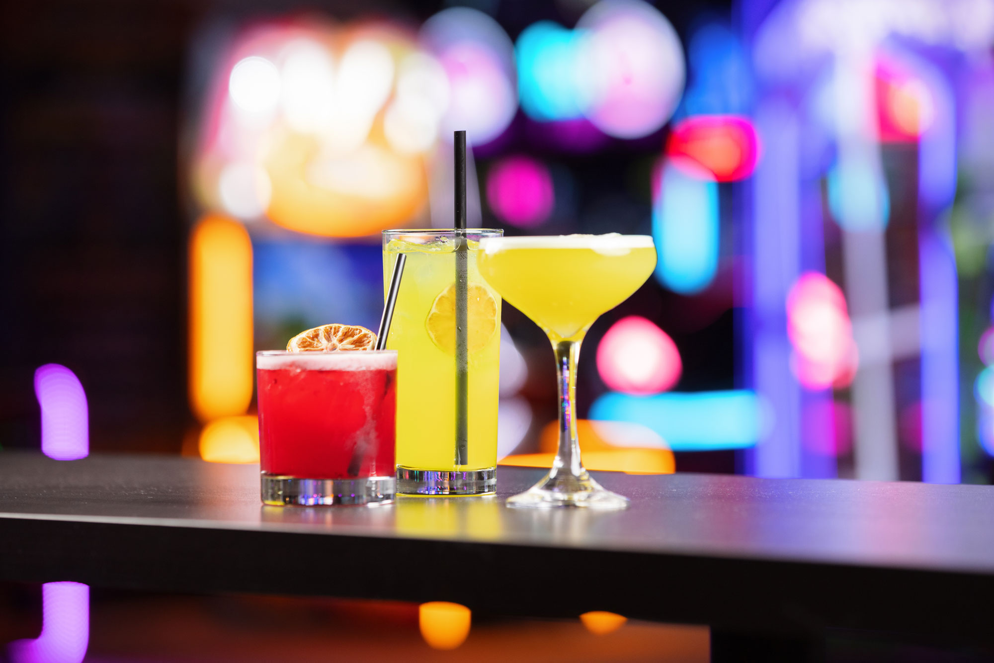 Colorful cocktails sitting on a bar