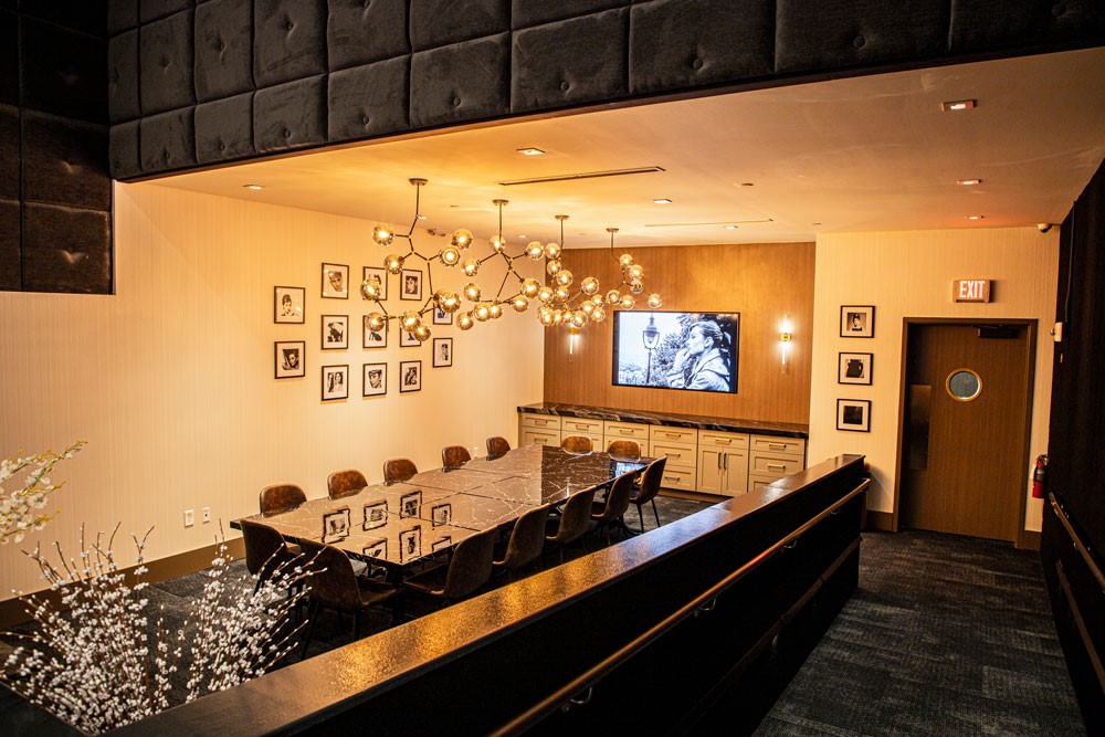 The Audrey events room with table, chairs, tv, chandelier, and decor