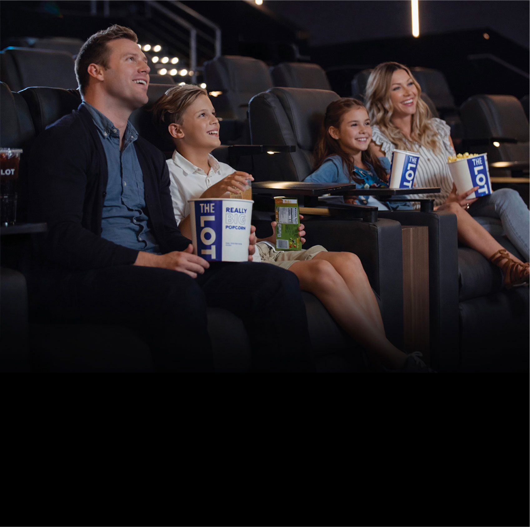 Family in movie auditorium eating popcorn