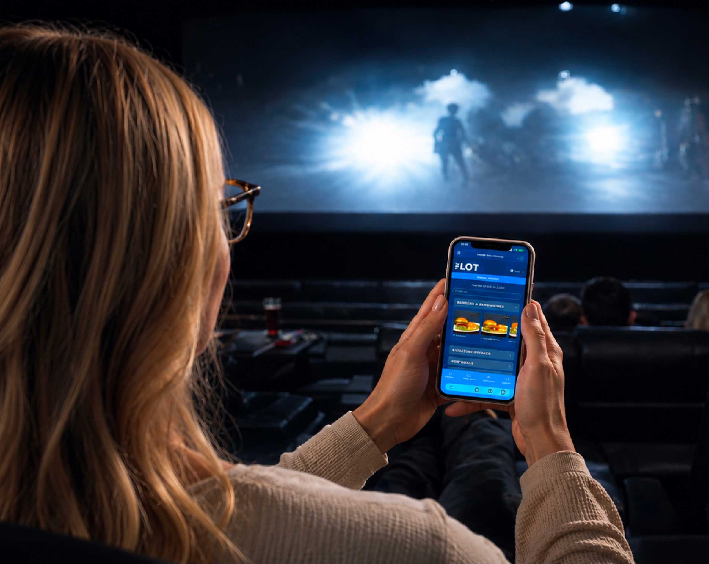 Person ordering food on a phone in movie auditorium
