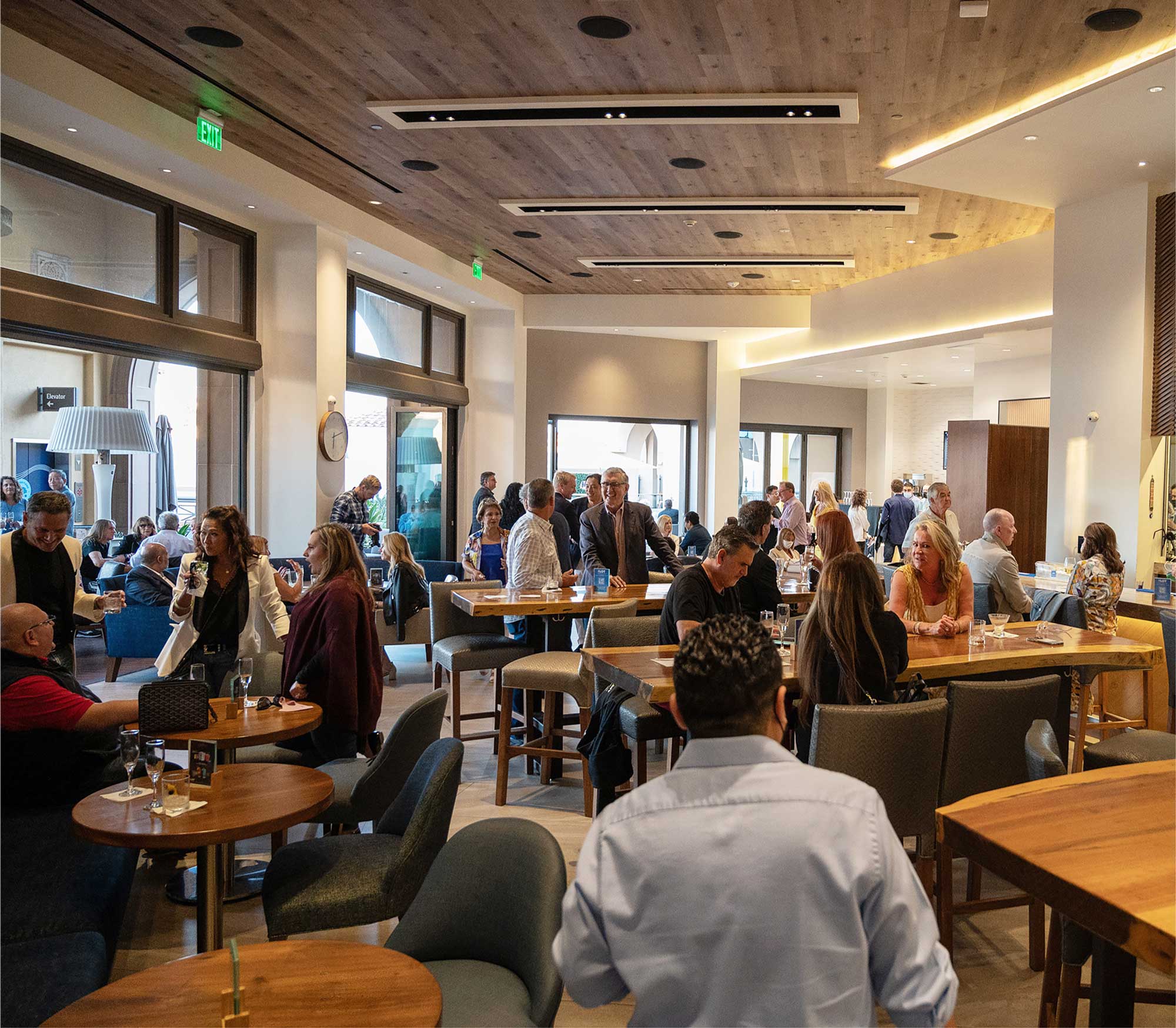 People sitting and standing around tables at a venue